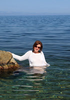 Мадам сидит голой жопой на прибрежных камнях 1 фото