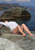 Мадам сидит голой жопой на прибрежных камнях 8 фотография