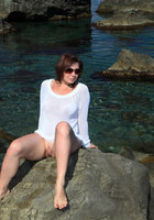 Мадам сидит голой жопой на прибрежных камнях 10 фото