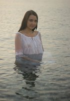 Прелестная милашка купается в озере в прозрачном платье 3 фотография