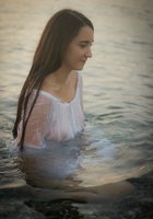 Прелестная милашка купается в озере в прозрачном платье 4 фотография
