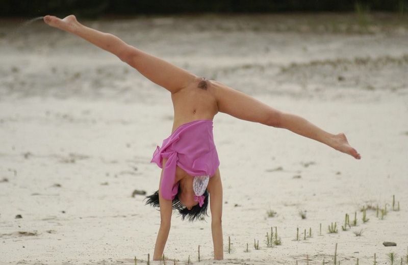 Художественная гимнастка занимается на морском берегу 7 фотография