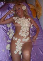 Блондинистая мамка обсыпала голое тело лепестками роз лежа на постели 15 фото