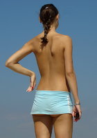 Хмурая девушка смыла с себя песок на нудистском пляже 8 фотография
