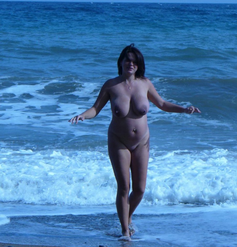 Бабенка выставляет на показ большие сиськи стоя на фоне моря 5 фотография