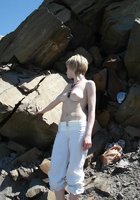 Развратная блондинка Алена загорает на скалистом берегу 1 фотография