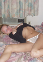 Блондинка позирует в белых стрингах на постели 9 фотография