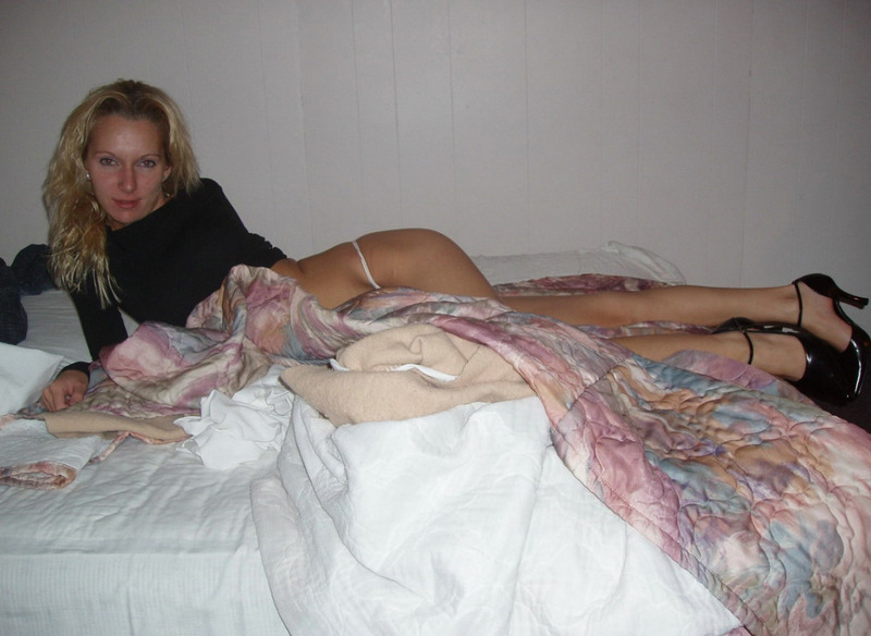 Блондинка позирует в белых стрингах на постели 1 фотография