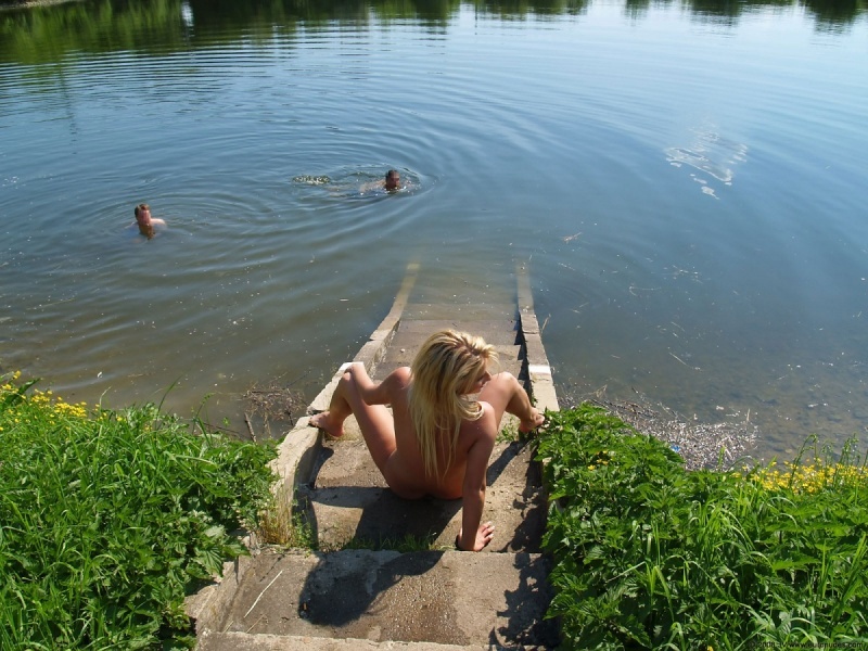 Блондиночка греет манду у небольшого озера 17 фотография