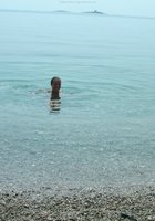 Грудастая шалашовка купается голышом на диком пляже 10 фотография