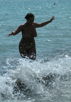 Грудастая шалашовка купается голышом на диком пляже 27 фото