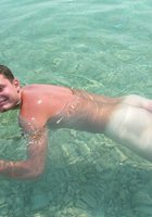Грудастая шалашовка купается голышом на диком пляже 13 фото