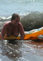 Грудастая шалашовка купается голышом на диком пляже 26 фото