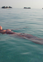 Сексуальна брюнетка голая отдыхает на берегу моря 15 фото