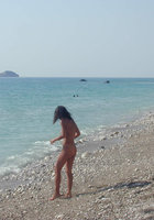 Сексуальна брюнетка голая отдыхает на берегу моря 13 фотография