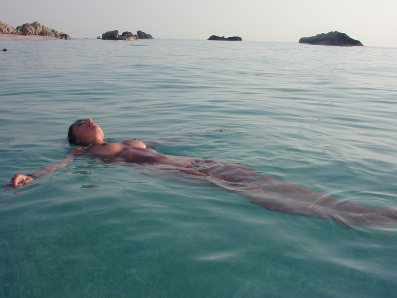 Сексуальна брюнетка голая отдыхает на берегу моря 15 фотография