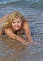 Сексуальная блондинка наслаждается отдыхом на море 14 фото