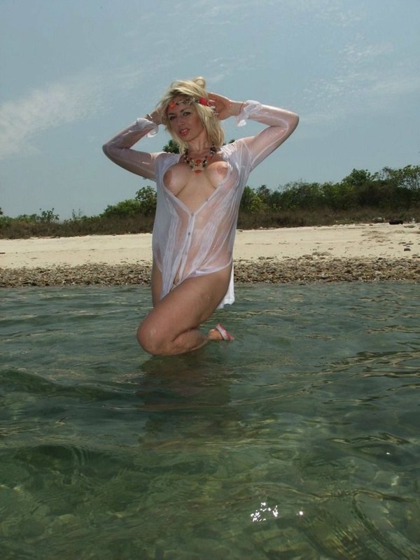 Блонда намочила белую блузку зайдя в море 3 фотография