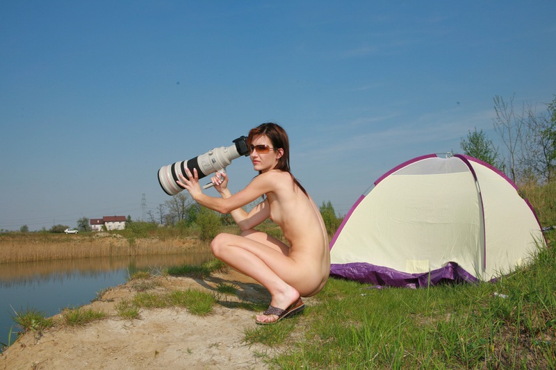 Голая нудистка вместе с парнем занимается съемкой у озера 14 фотография