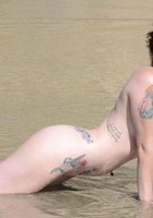 Татуированная нудистка пришла на море 12 фотография