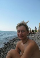 Баба лежит топлес на каменистом пляже 11 фото