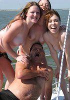 Три молодые подруги стоят на палубе яхты топлес 7 фотография
