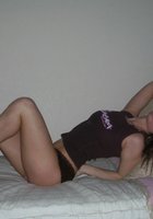 Карина в позирует на кровати в коричневых трусах и футболке 4 фото