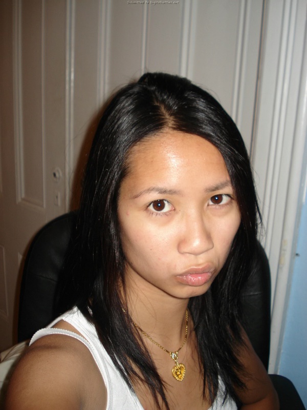 Молоденькая азиатка светит киской в комнате с выключенным светом 1 фотография