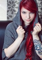 Красноволосая Сара ваяется на черном диване без белья 5 фото