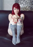 Красноволосая Сара ваяется на черном диване без белья 21 фотография