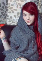 Красноволосая Сара ваяется на черном диване без белья 17 фото