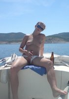 Жена пьет пиво катаясь на яхте в плавках 28 фотография
