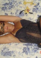Длинноволосая хозяйка позирует на кровати в черном белье 14 фото