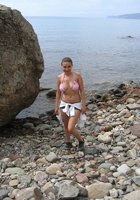 Сисястая девушка гуляет по морскому берегу 9 фото