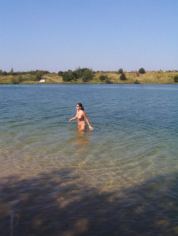 Голая стерва купается в озере в солнечную погоду 9 фотография