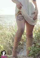 Красивая дева хвастается собой в траве на берегу моря 10 фото