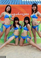 Азиатские черлидерши в купальниках тренируются на песке 5 фото