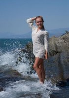 Голая девушка позирует на скалистом берегу моря 1 фотография