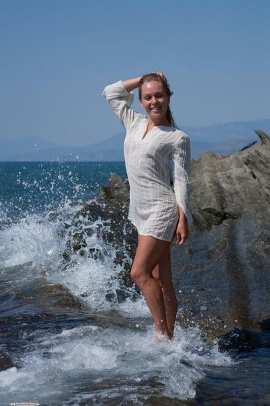 Голая девушка позирует на скалистом берегу моря 1 фотография