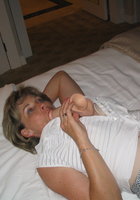 Женщина на кровати позирует с голыми титьками 12 фотография