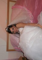 Развратная невеста в белых чулках позирует на кровати 1 фото