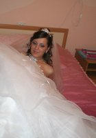 Развратная невеста в белых чулках позирует на кровати 3 фотография