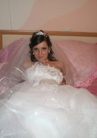 Развратная невеста в белых чулках позирует на кровати 9 фотография