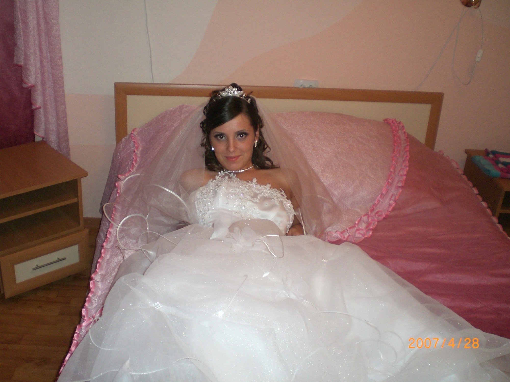 Развратная невеста в белых чулках позирует на кровати 9 фотография