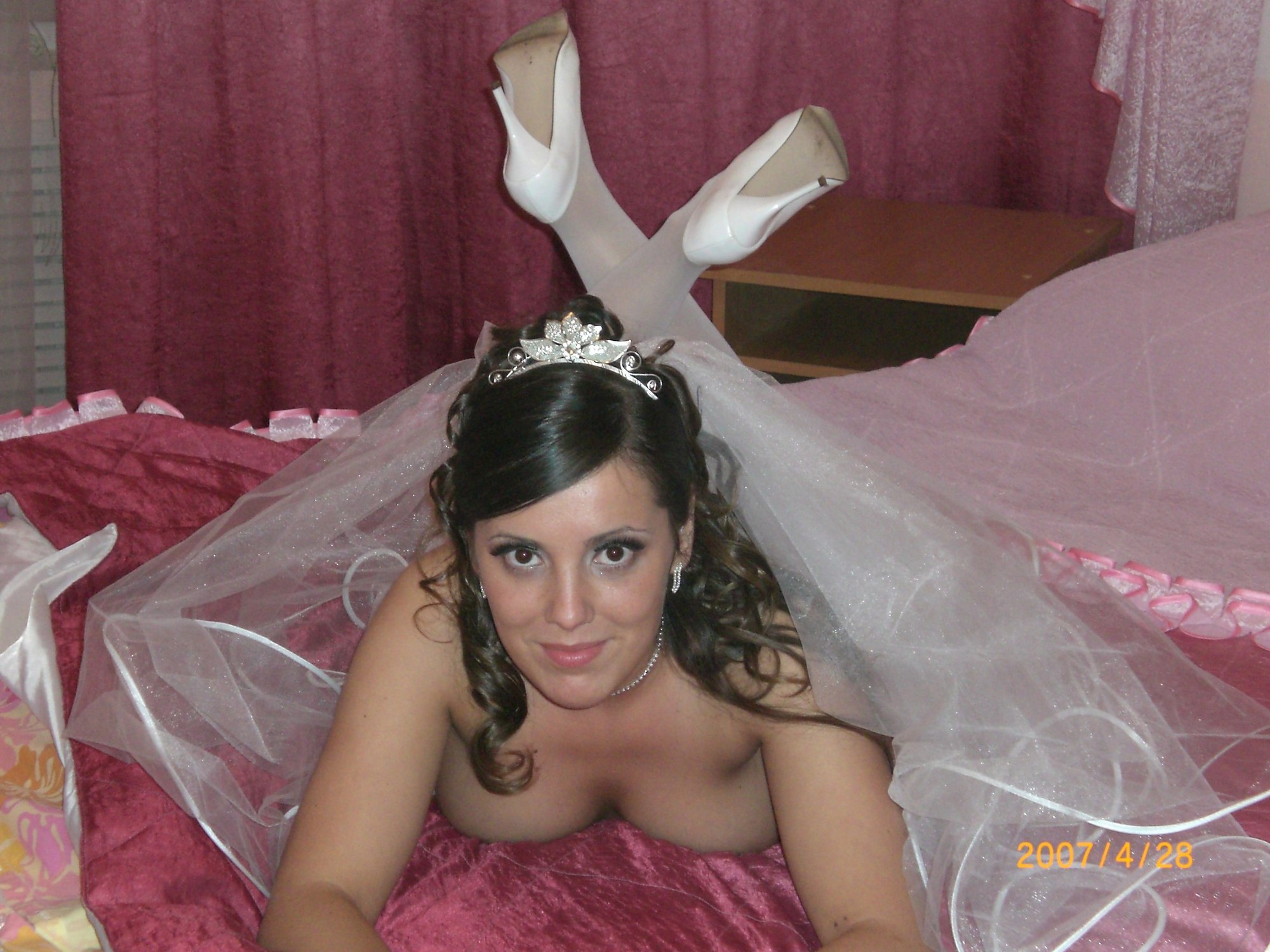 Развратная невеста в белых чулках позирует на кровати 18 фотография