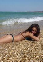 Молодая красотка сексуально позирует на море 15 фотография