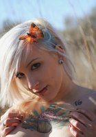 Татуированная блондинка оголила грудь в поле 4 фотография