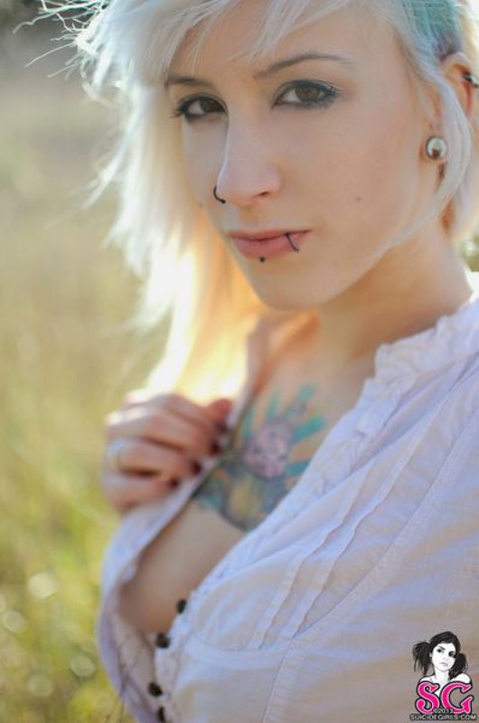 Татуированная блондинка оголила грудь в поле 3 фотография