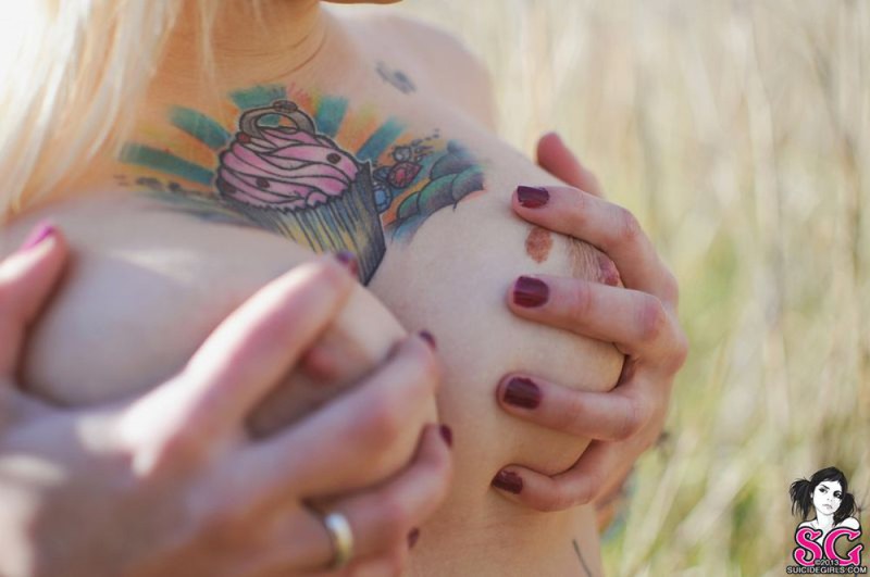 Татуированная блондинка оголила грудь в поле 18 фотография