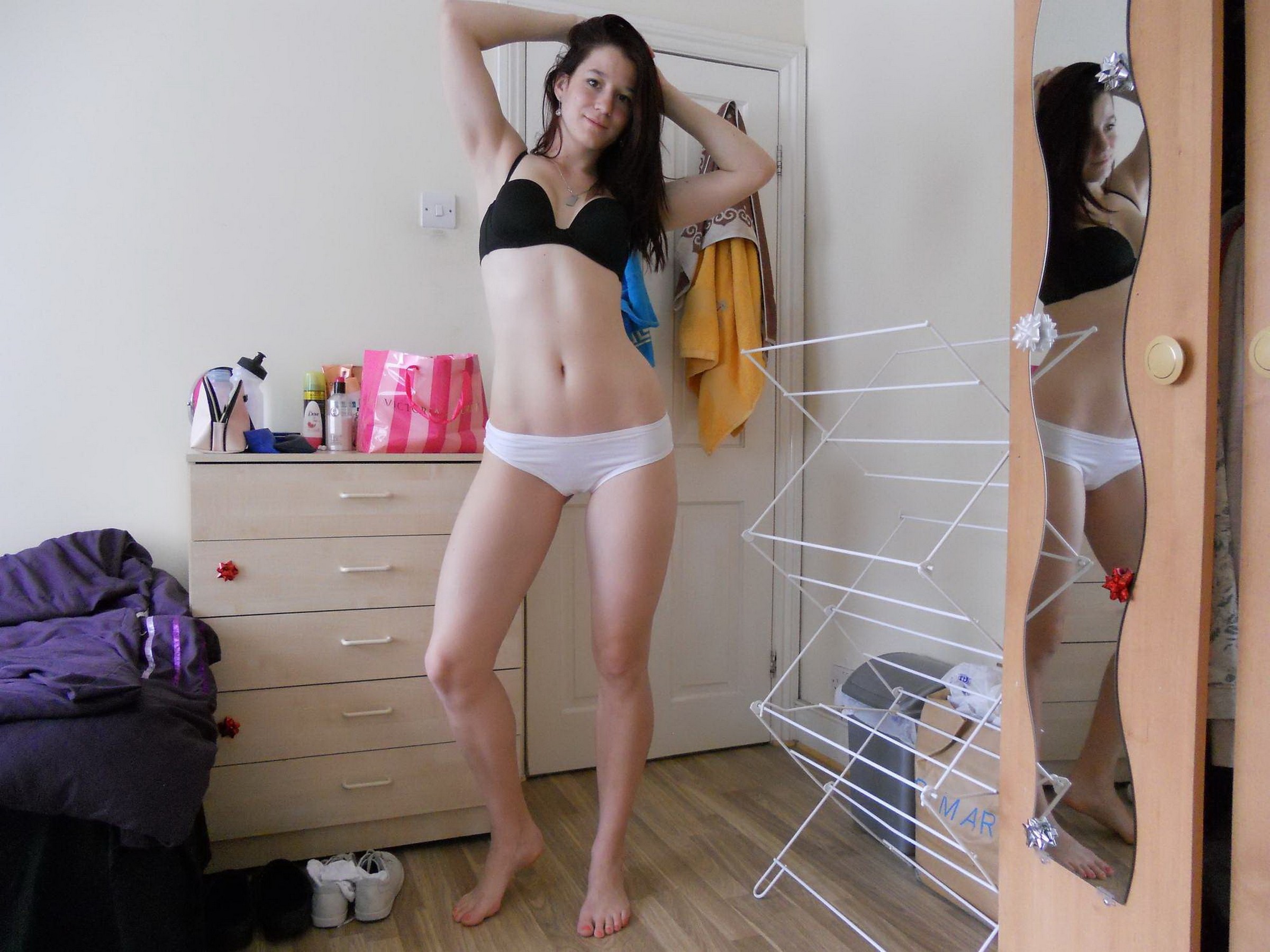 Красивая девушка позирует в нижнем белье у себя в комнате 10 фотография
